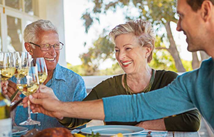 Family clinking wine glasses together smiles in Pryor, OK