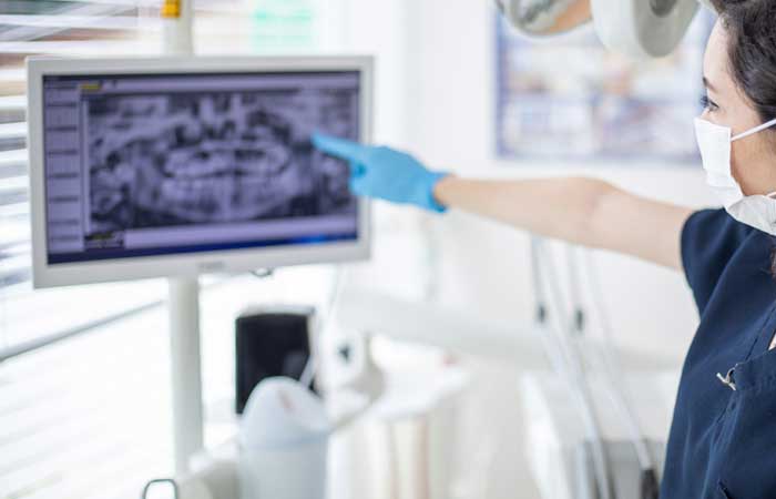 Dental assistant point to digital x-rays