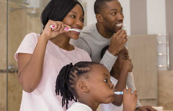 Family of three brushing their teeth, preventive care in Pryor, OK